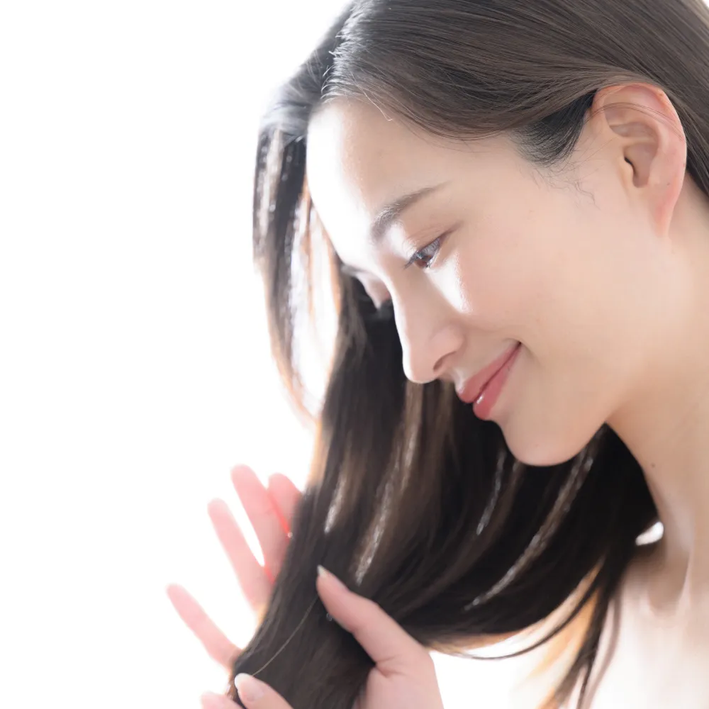 髪を手で撫でながら優しく微笑む女性の横顔